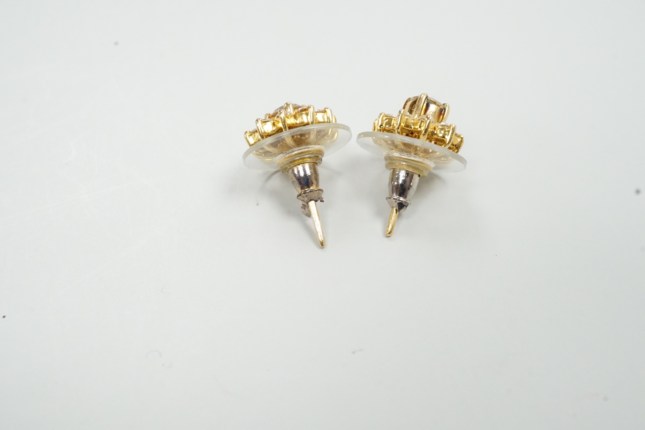 A modern pair of yellow metal and diamond cluster set flower head ear studs, with detachable collars